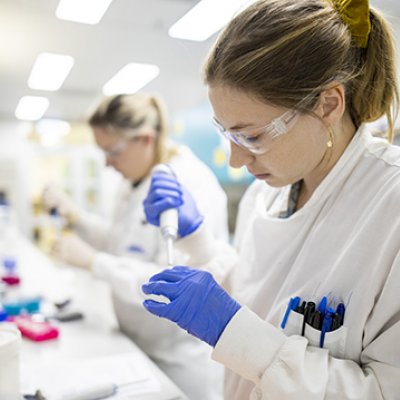 Two female researchers work at the lab bench as part of the vaccine project at UQ